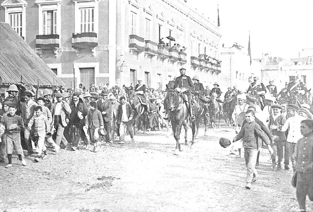 Alfonso XIII entra a caballo en Melilla en enero de 1911, entre vecinos y niños que corren delante de la comitiva