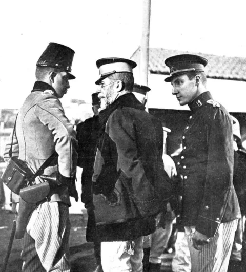 Tres militares de uniforme conversan en el muelle