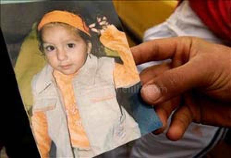 Un familiar sujeta una foto de la pequeña Mari Luz