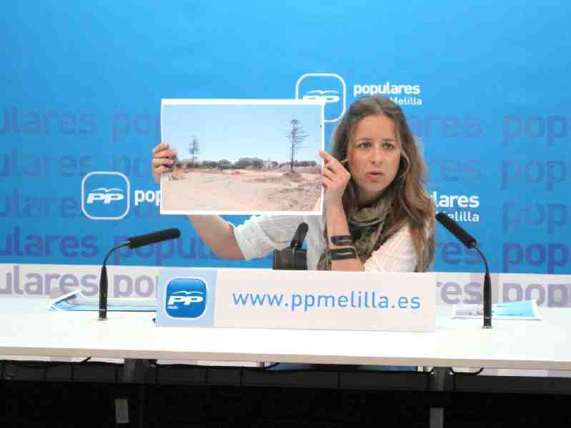 Katty Muriel mostrando una fotografía del solar vacío