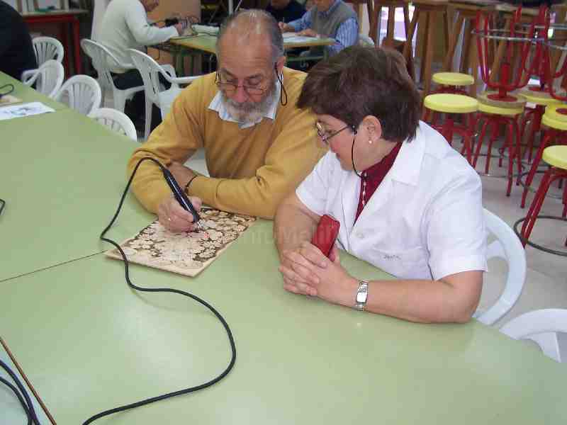 El artista melillense enseñando el arte del Pirograbado a una de sus alumnas