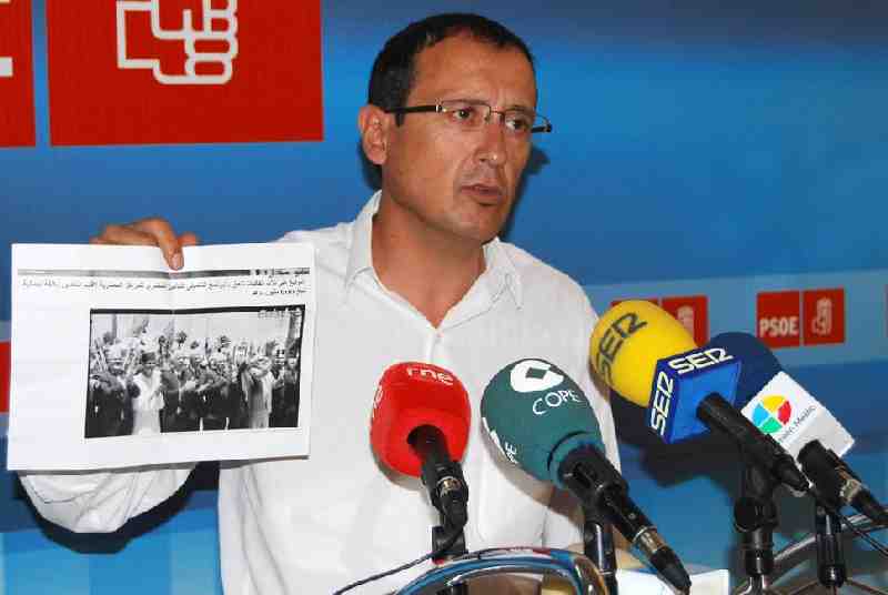 Dionisio Muñoz mostrando la fotografía en la que tres asesores del Ejecutivo de Imbroda aclaman al R