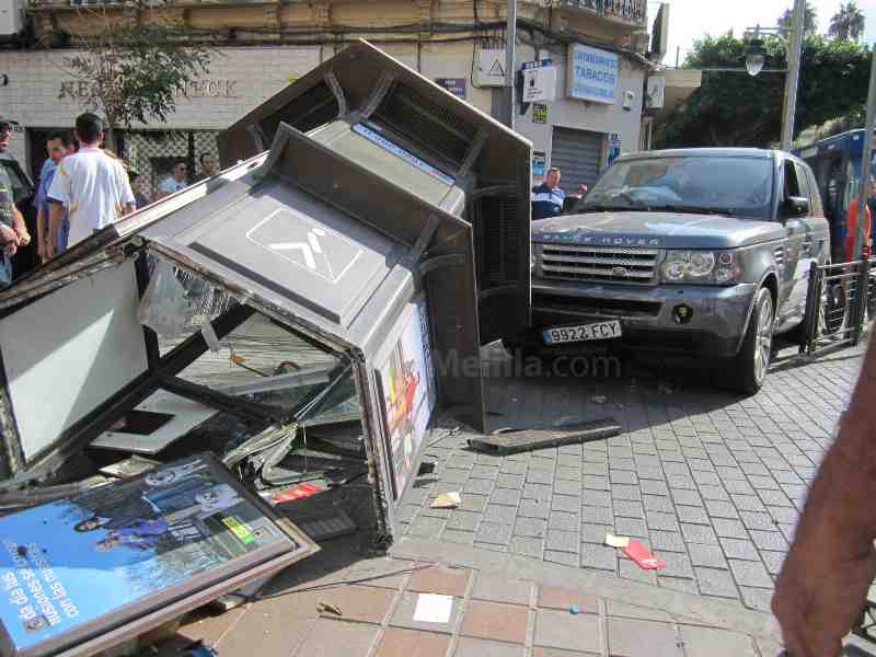 Un aparatoso accidente entre dos coches acaba con un puesto de loterías destrozado