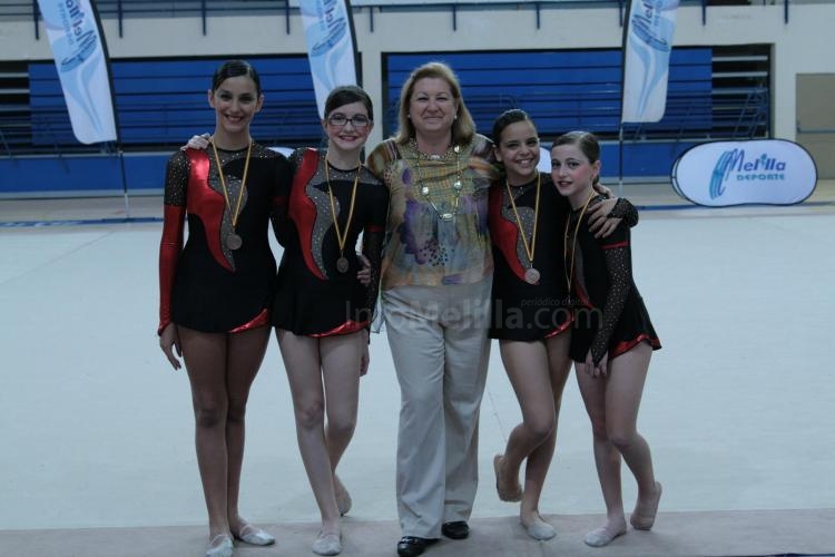 María Jesús Conca junto a tres gimnastas locales