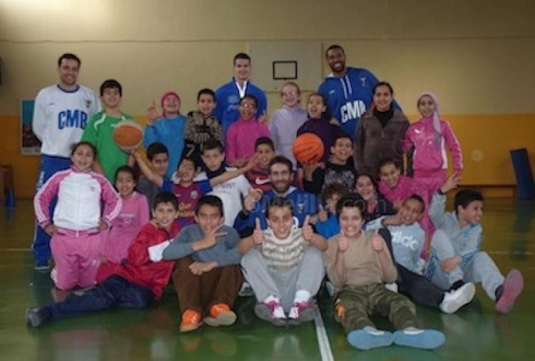 Jugadores y ayudante del entrenador de Melilla Baloncesto, junto a los alumnos del León Solá