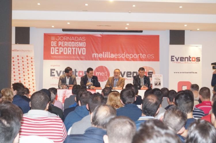 Público asistente con los ponentes de fondo